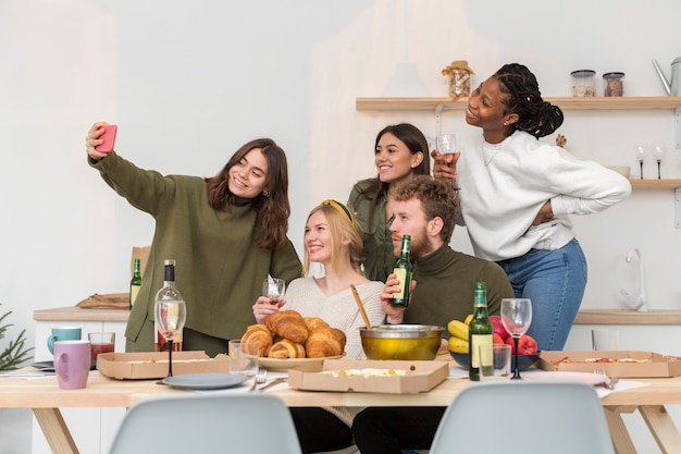 Uśmiechnięte osoby jedzące przy stole